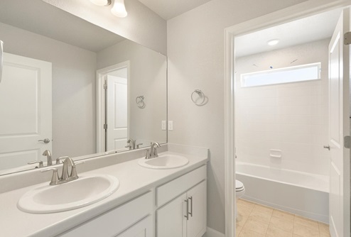 white cabinet bathroom with dual-sink and toilet and tub in a separate room