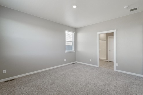 carpet floor bedroom with a window, ceiling light, and a door to bathroom