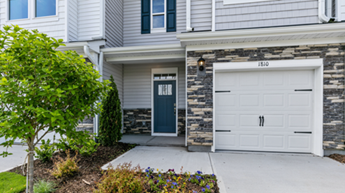 Front exterior of a Denver floorplan home featuring white and grey siding with stone accents