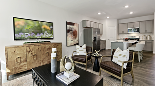 living room featuring beige sofa, 2 accent chairs and brown and green decor