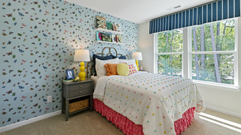bedroom featuring childs decor and a large window