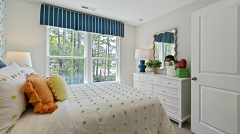 bedroom featuring childs decor and a large window