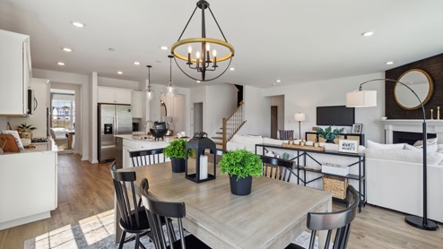 Overview of the entire open layout with the back sliding glass door behind. View of the eating nook, living, and kitchen area.