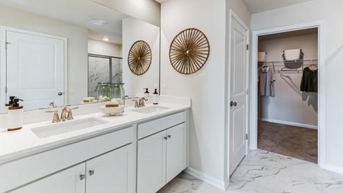Bathroom with double sink, linen closet, and clothes closet.