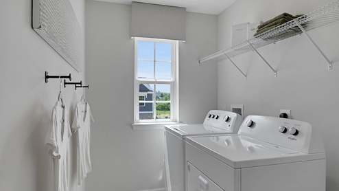 Laundry room with washer and dryer. Shelf above washer and dryer.