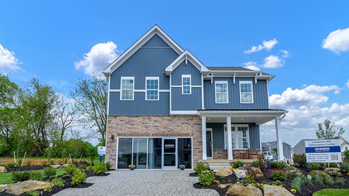 Exterior image of a two story navy and brick home with double garage.