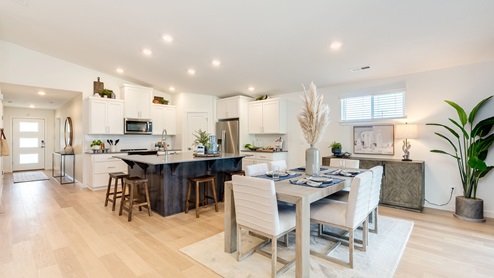 Kitchen with shaker cabinets, quartz counters, stainless steel appliances, pantry, and an island with a breakfast bar