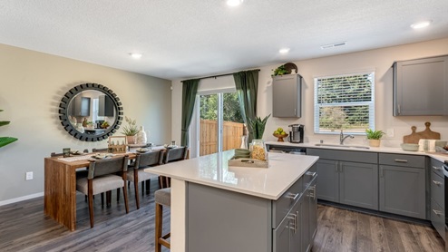 Kitchen with shaker cabinets, quartz counters, stainless steel appliances, pantry, and an island with a breakfast bar