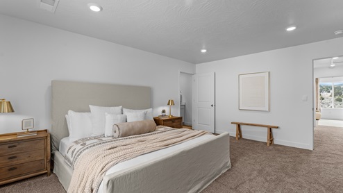 Spacious primary bedroom with doors into bathroom and hallway.