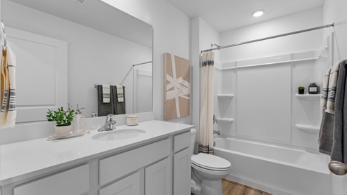 Full size bathroom with white cabinets and a tub shower combination.