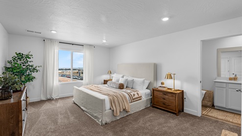 Spacious primary bedroom with a large window.