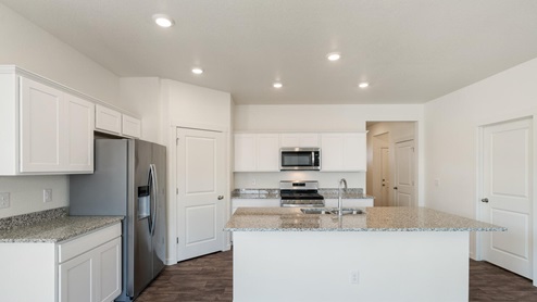 white cabinet kitchen with stainless steel appliances, ceiling light, and wood floor