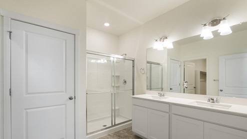 white cabinet bathroom with a shower, and dual sink