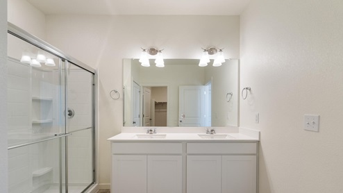 bathroom with dual-basin sink and white cabinets