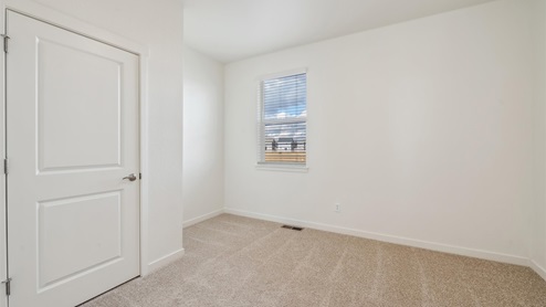 carpet floor bedroom with a window and door to bathroom