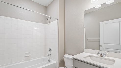 gray cabinet bathroom with a tub