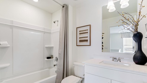 bathroom with a tub and white cabinets