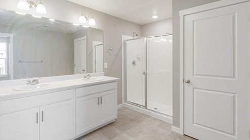 white cabinet bathroom with a shower and two sinks