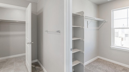 walk in closet with shelves and a window