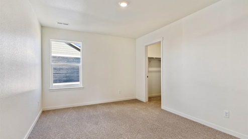 white wall bedroom with a window and carpet floor