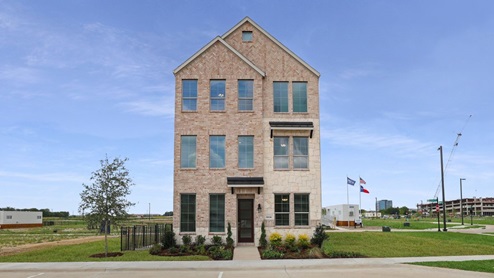 Front exterior of a three story home with light brick and stone accents
