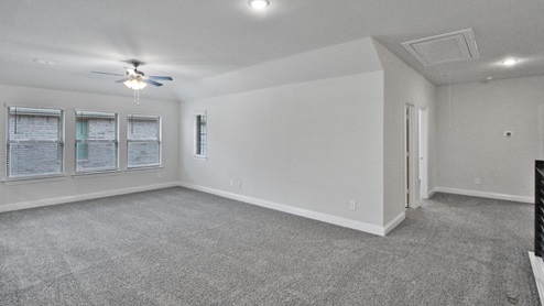 Bright and airy loft area with carpeted flooring, modern railing, and ceiling fan lighting. The open design overlooks the main living space below, creating a perfect spot for relaxation or additional living space.