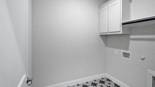 Spacious laundry room with washer and dryer connections, hanging rod, and vinyl wood flooring A laundry room featuring a washer and dryer, neatly arranged with ample space for laundry tasks and storage.