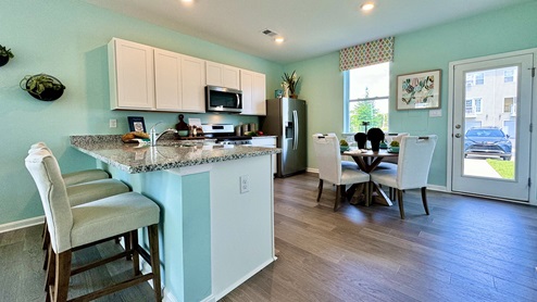 Bright kitchen with peninsula island and white cabinets.