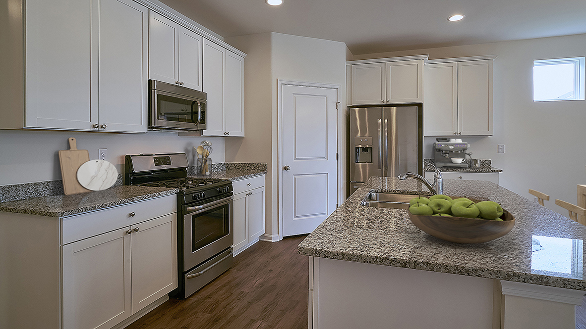 The open kitchen boasts a large island with quartz countertops.