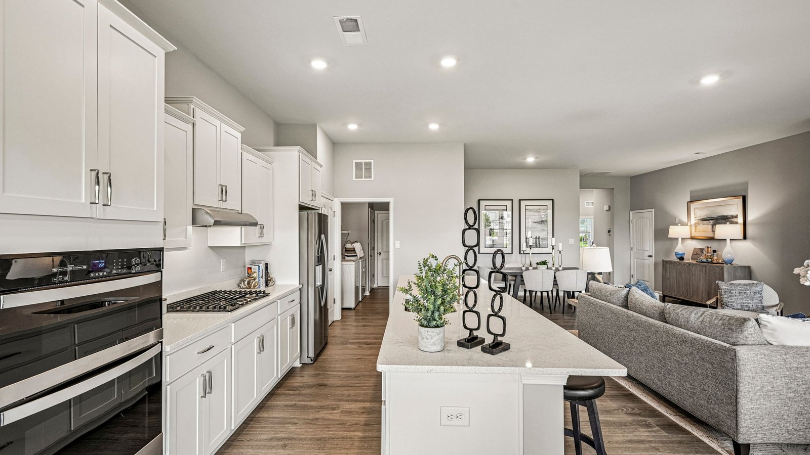 The open floorplan features a well-designed kitchen complete with stainless steel appliances.