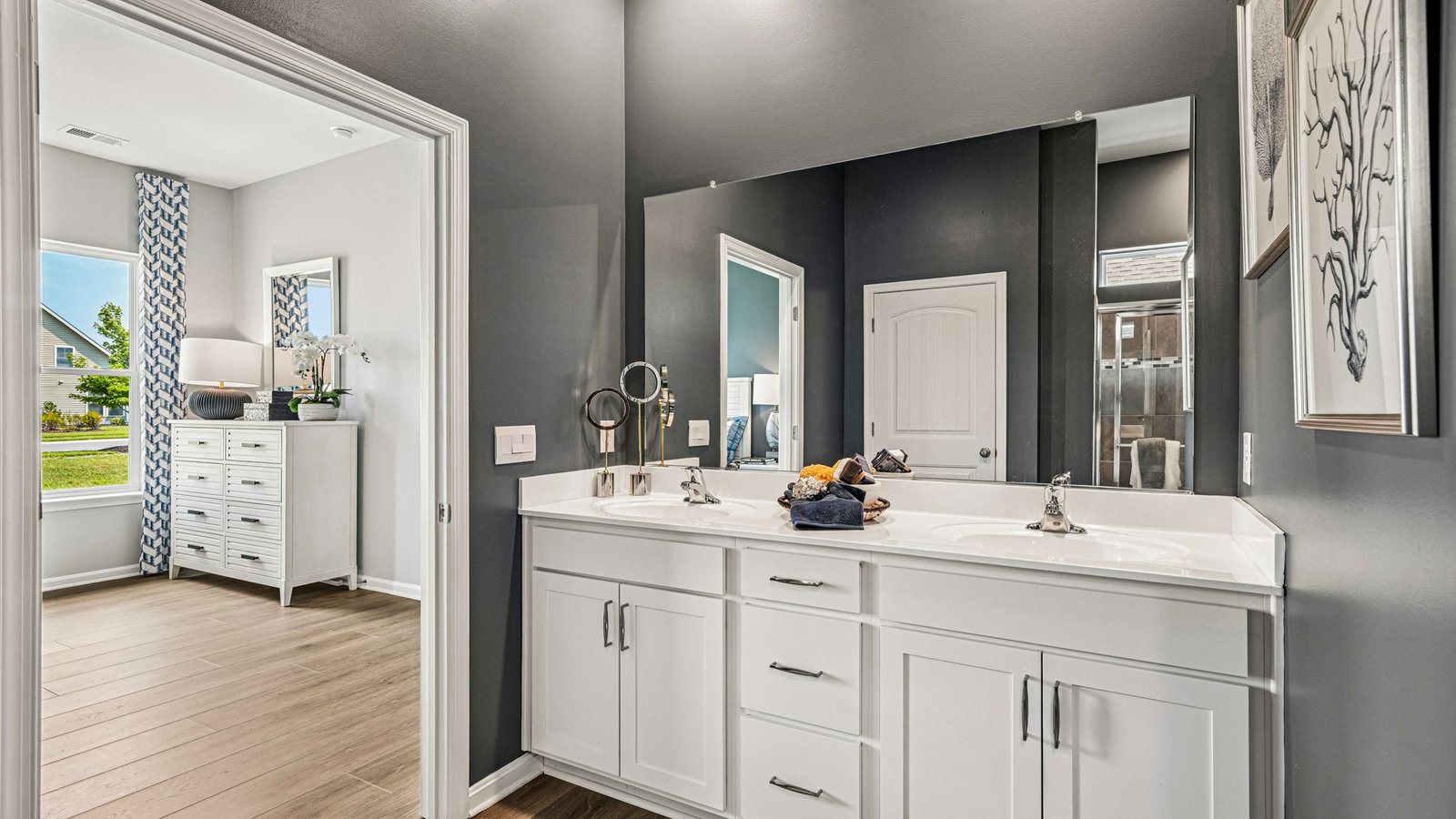 The spacious bathroom with a luxury shower has a double-bowl vanity.