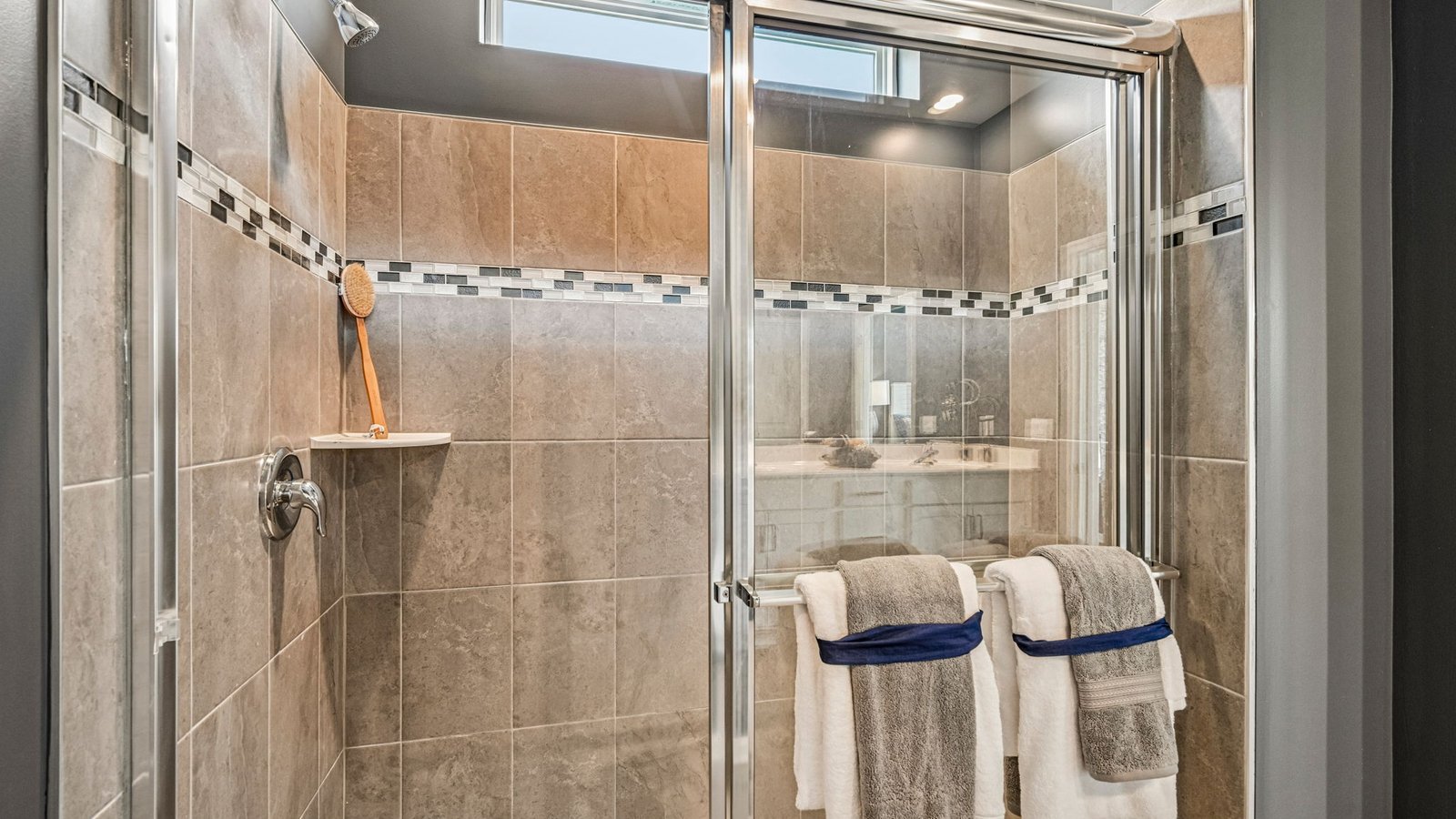 The spacious bathroom with a luxury shower has a large walk-in closet.