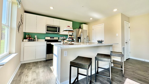 Open-concept kitchen with white cabinets and a large island.