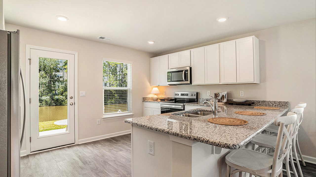 The well-appointed kitchen features an abundance of cabinetry, stainless steel appliances, a corner pantry and a peninsula island with additional room for seating.