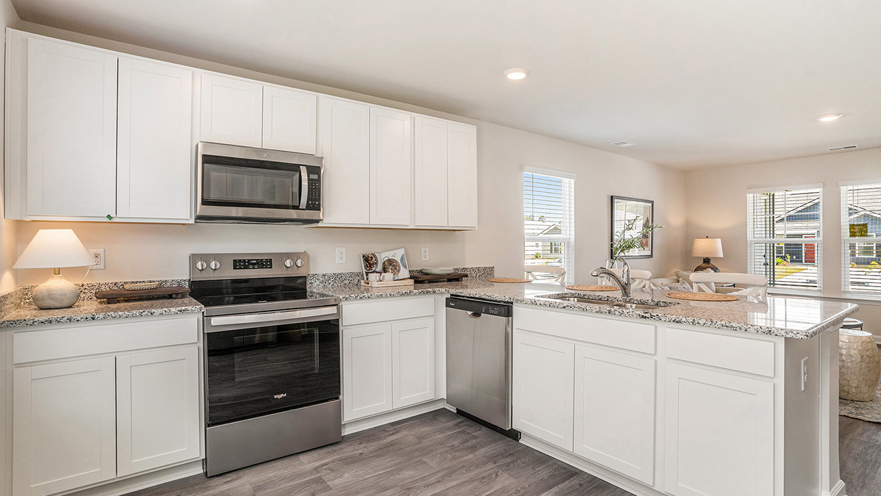 The well-appointed kitchen features an abundance of cabinetry, stainless steel appliances, a corner pantry and a peninsula island with additional room for seating.