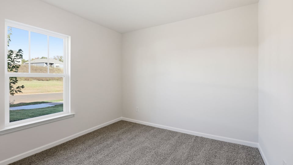 Bedroom with carpet and window.