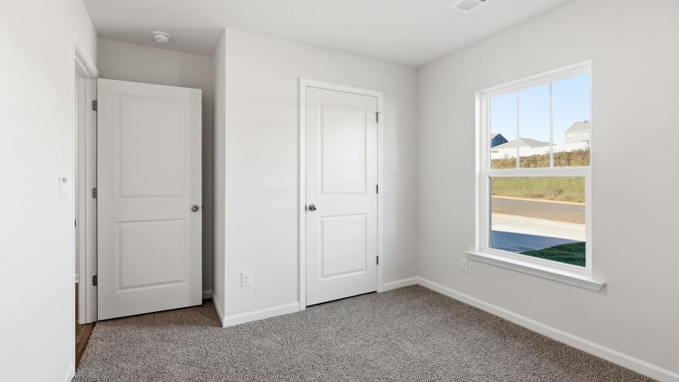 Bedroom with carpet and window.