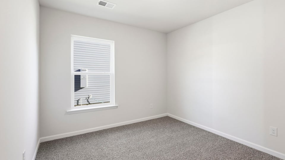 Bedroom with carpet and window.