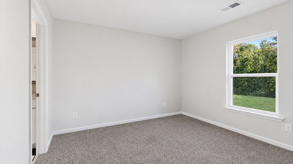 Bedroom with carpet and window.