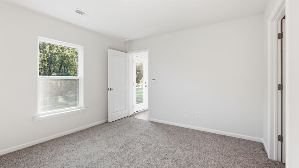Bedroom with carpet and window.