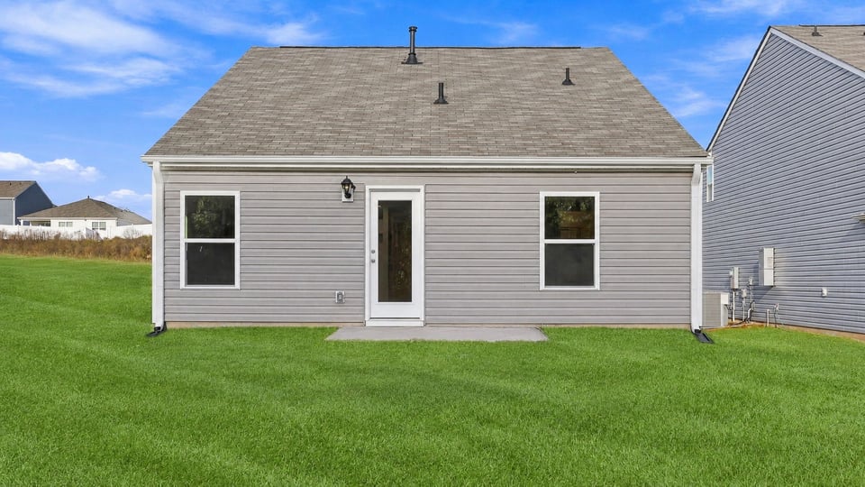 Back exterior of home with lareg backyard.