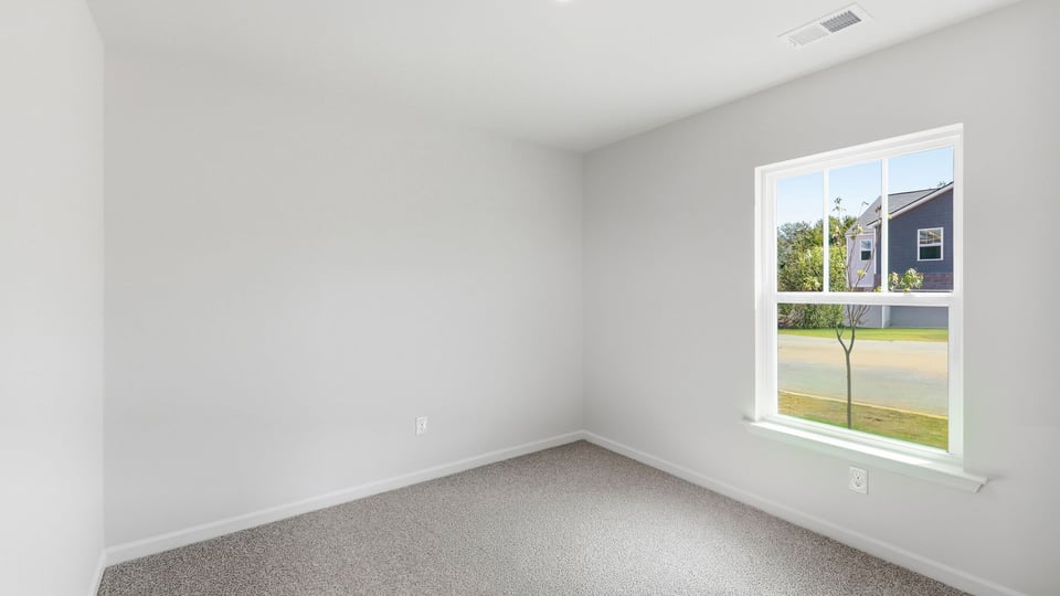 Bedroom with carpet and window.