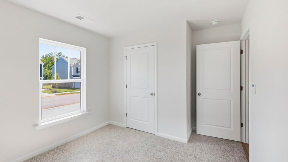 Bedroom with carpet and window.