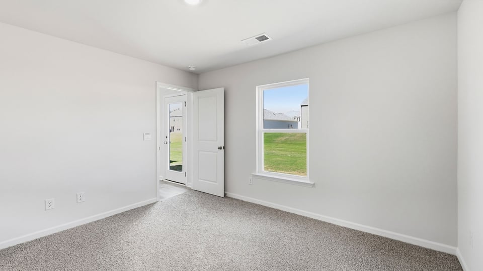 Bedroom with carpet and window.