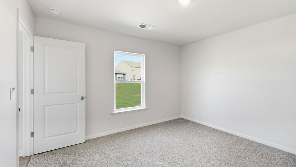 Bedroom with carpet and window.
