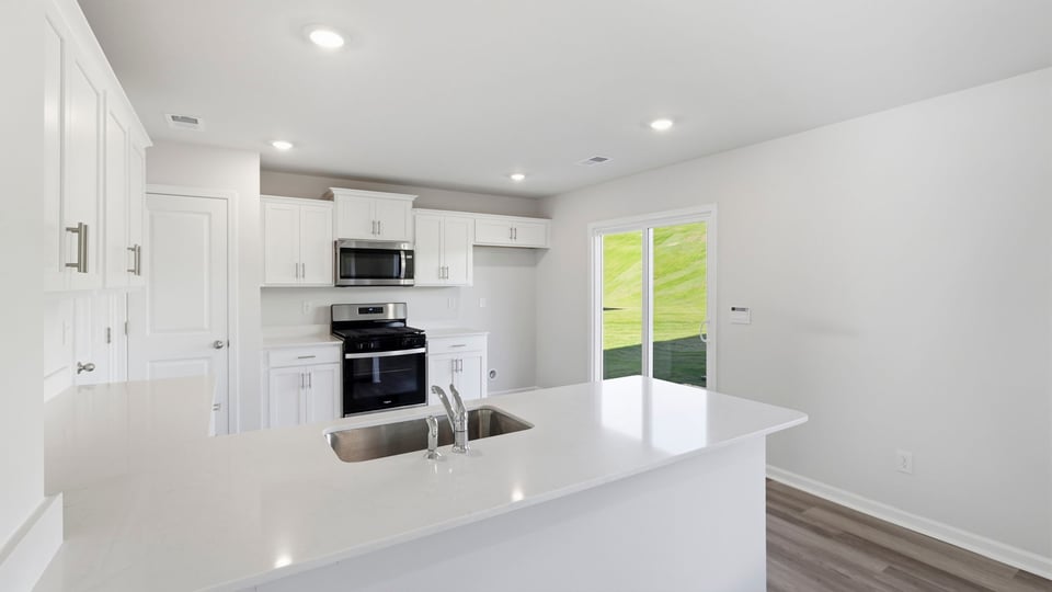 Kitchen with stainless steel appliances and quartz countertops.