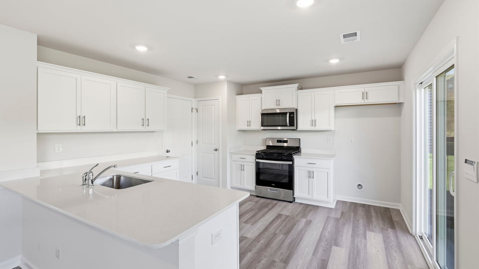 Kitchen with stainless steel appliances and quartz countertops.