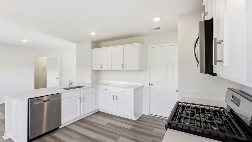 Kitchen with stainless steel appliances and quartz countertops.