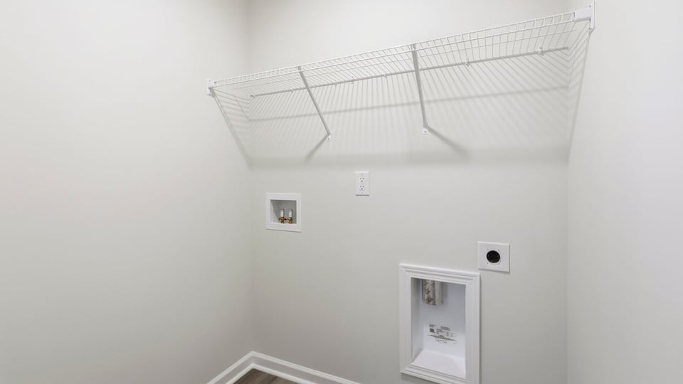 Laundry room with hanging storage racks.