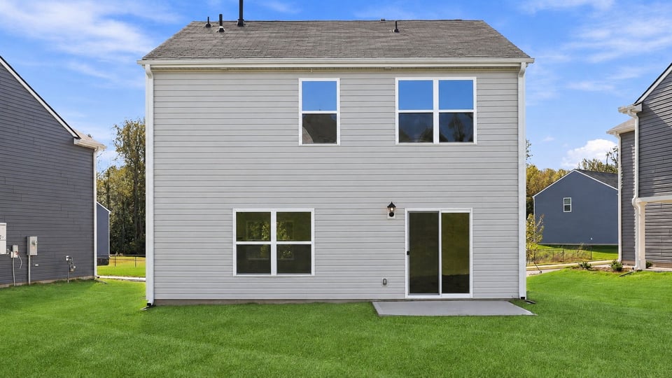 Back exterior of home with large backyard.